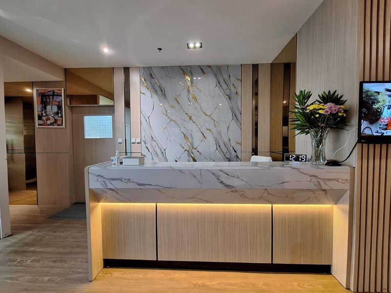 Meja resepsionis dengan dinding marmer dan panel kayu